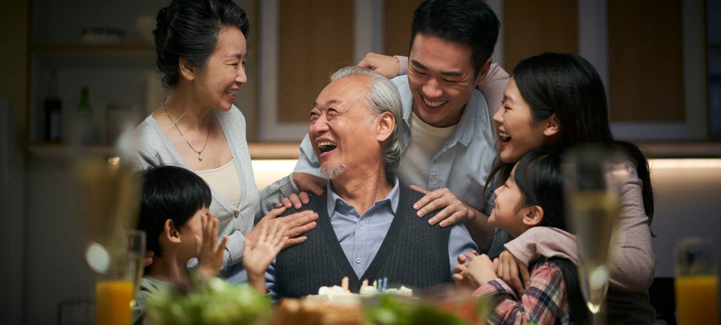 happy three generation asian family celebrating grandpa's birthday at home