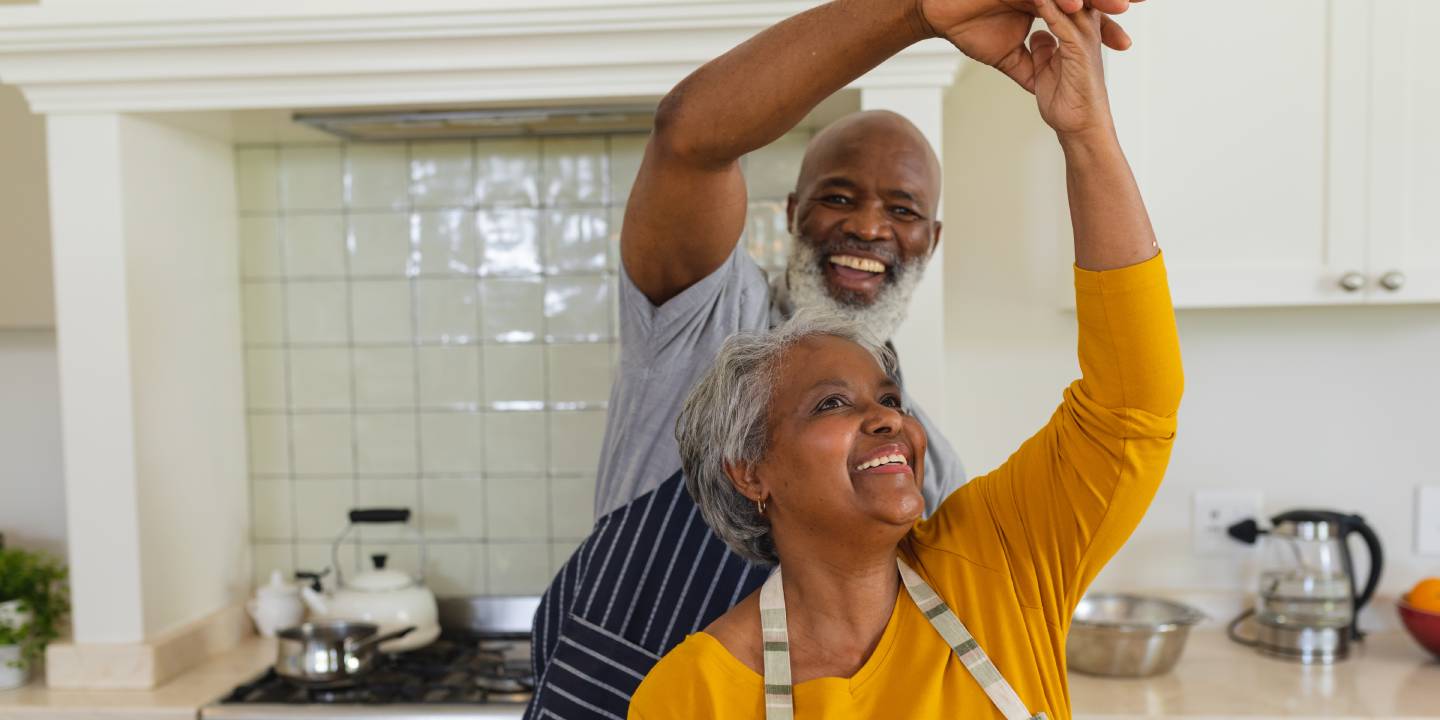 couple dancing together in kitchen smiling