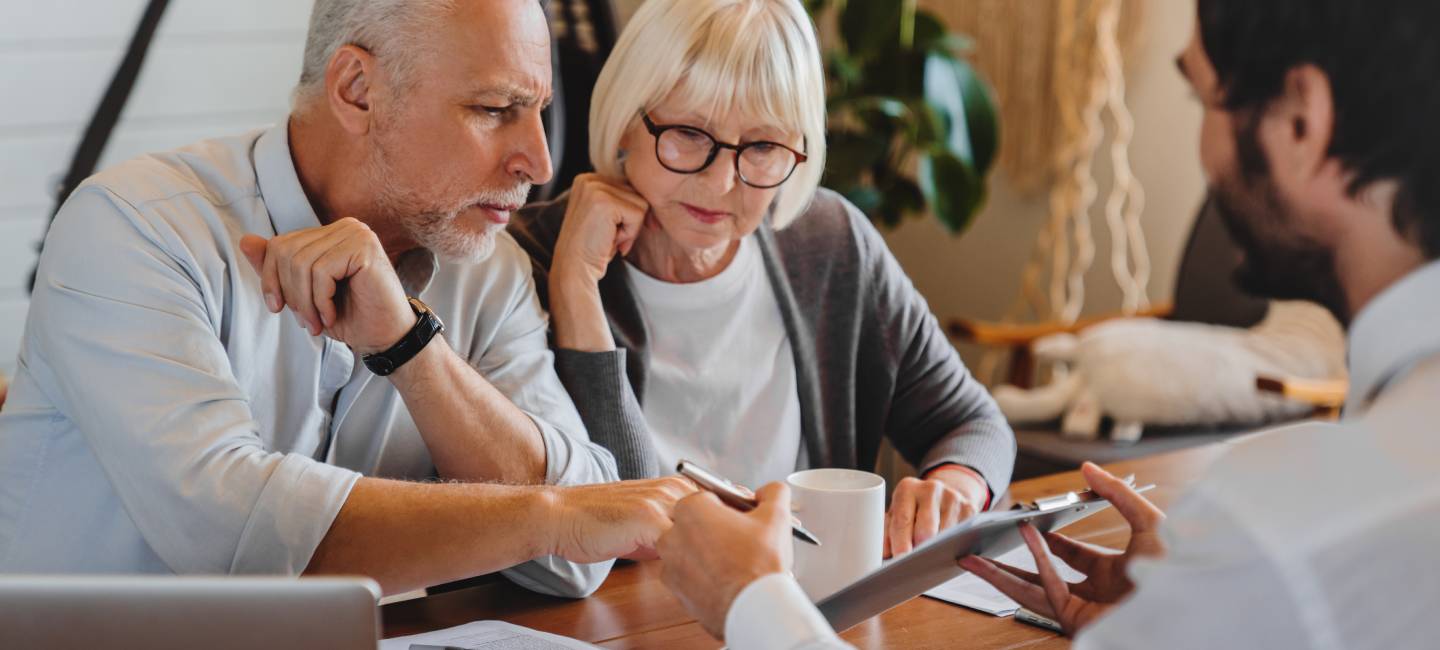 Senior couple discussing wills with lawyer