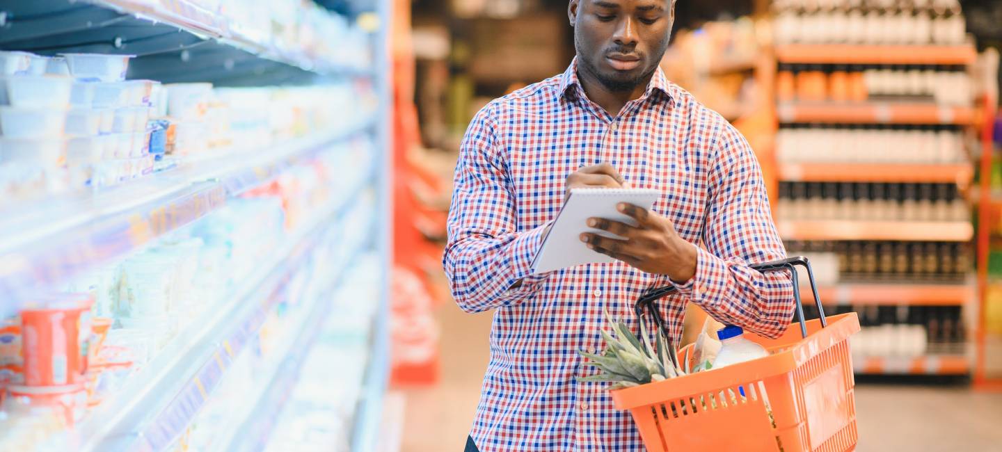 Mature man shopping at supermarket, filling his basket with food