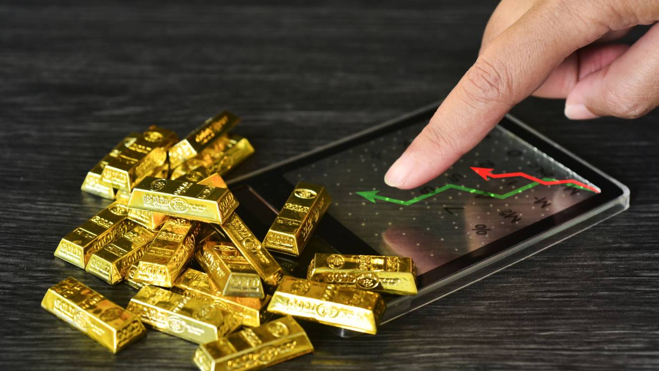 Gold bar on calculator with trading line graph for calulate the gold price. Gold is hard commodity , risk asset, tangible value that used to be gold reserve, save assets during war and economic crisis