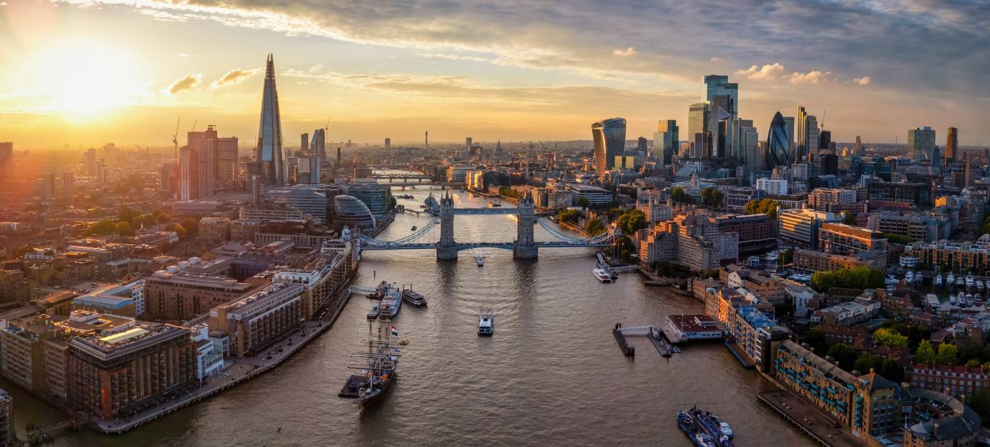 Panoramic aerial view of the skyline of London, England, with Tower Bridge, River Thames and City skyscrapers during a colorful sunset