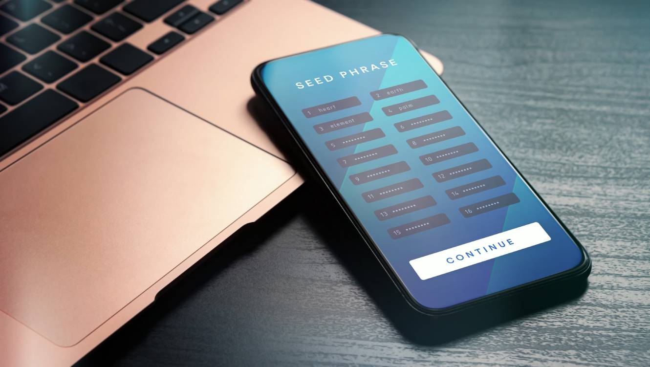 A blue mobile on a bronze laptop both laying on a table