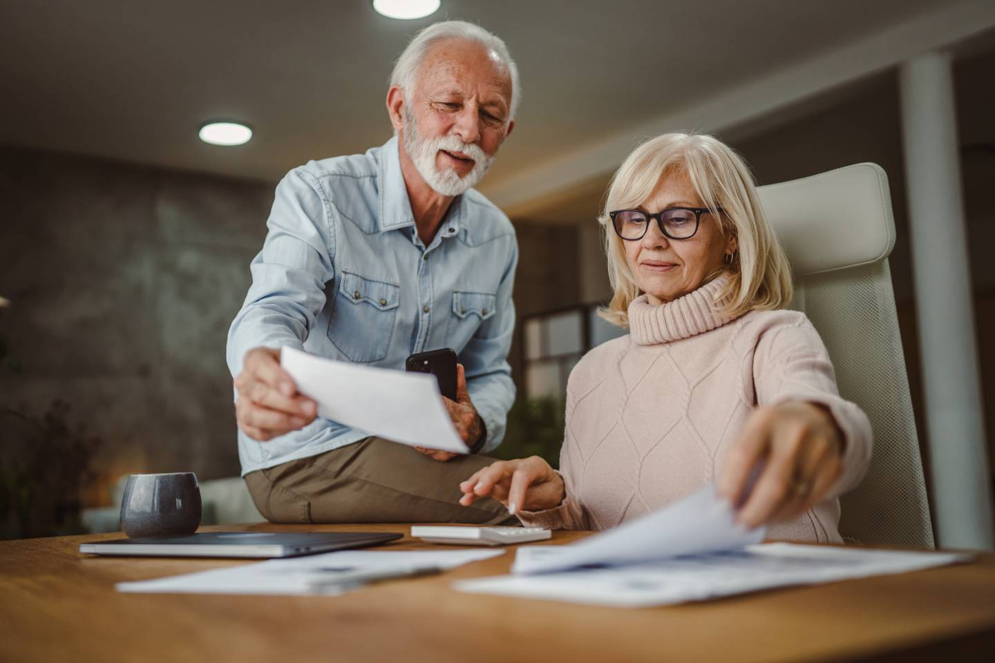 Senior couple do contactless payment and caluclate bills together