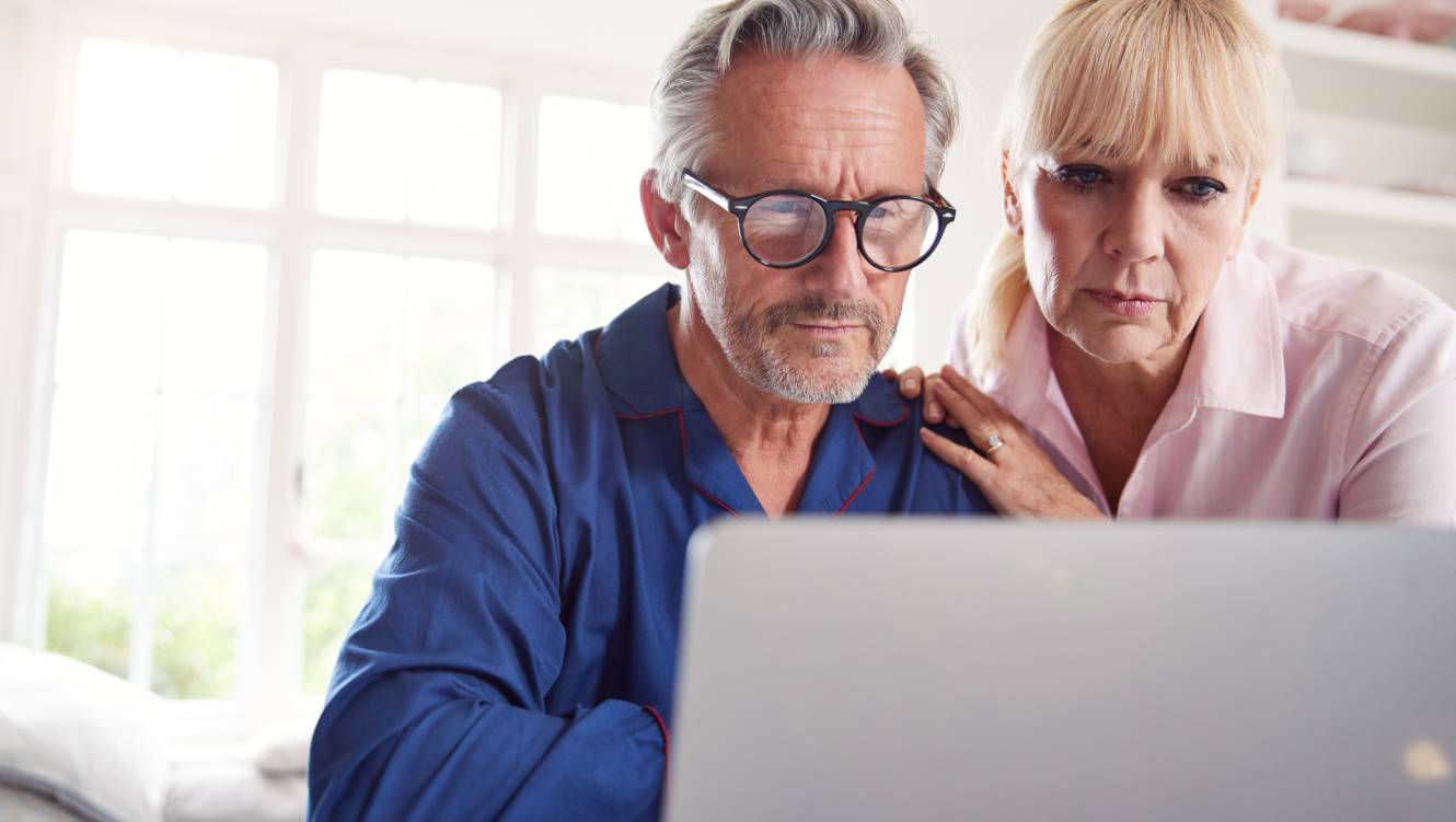 Mature Couple At Home Looking Up Information About Medication Online Using Laptop