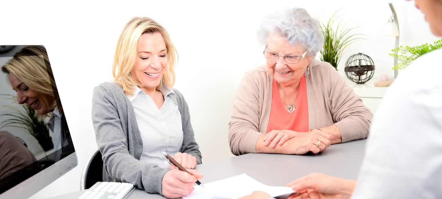 Elderly senior woman with daughter signature legacy heritage testament document in a lawyer notary office 