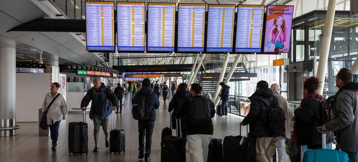  Tourists and passengers walk with their luggage to the gate of their plane at Schiphol Airport in Amsterdam.
