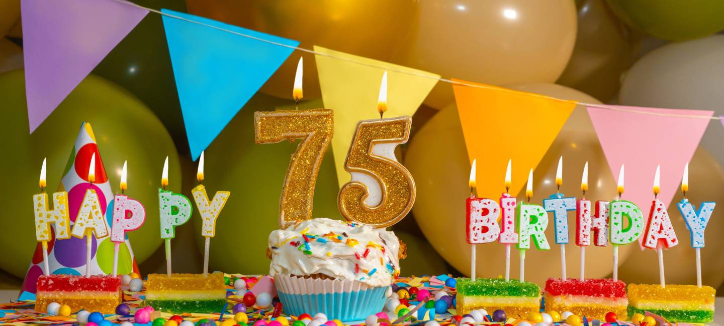 Creamy cupcake with candle for seventy five years, colorful happy birthday card for 75 year old, birthday cupcake with candles and birthday decorations