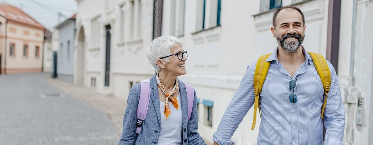 A cheerful mature couple exploring the city while holding hands