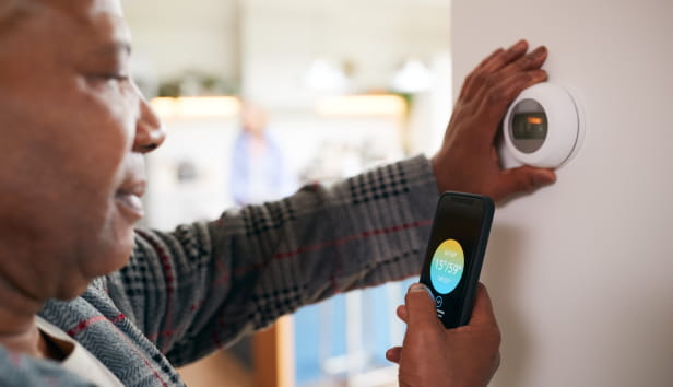 A man looking at his digital thermostat