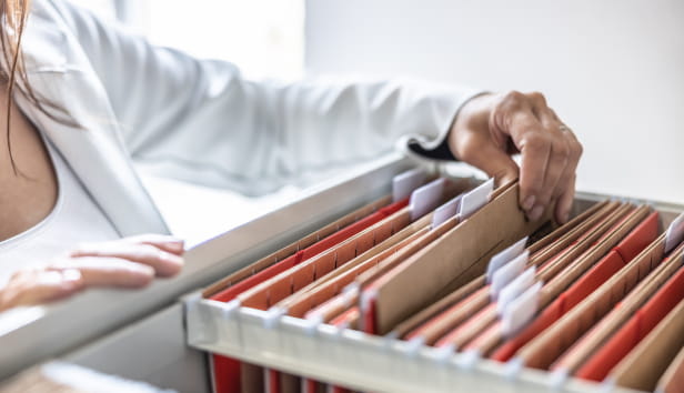 A woman looking through a filing cabinet