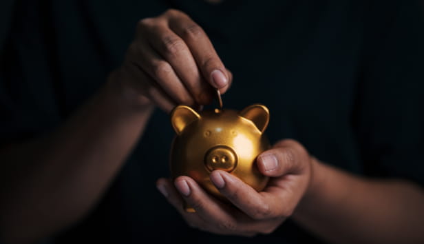 Man placing coin in piggy bank