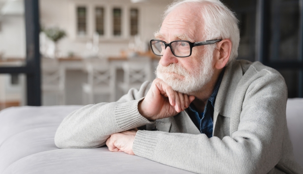 Man looking glum with his chin resting on his hand