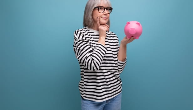 A woman holding a pink piggy bank