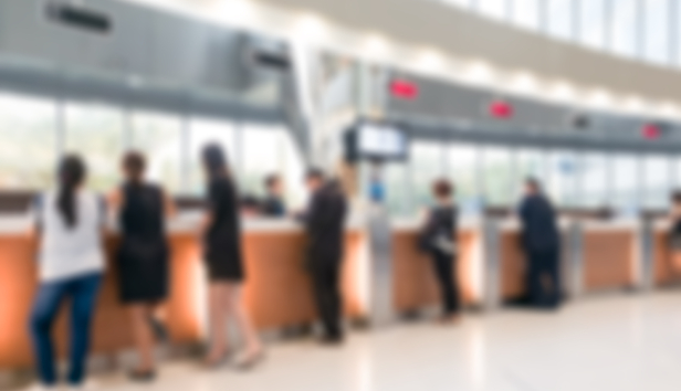 People standing at counters at a banking hub