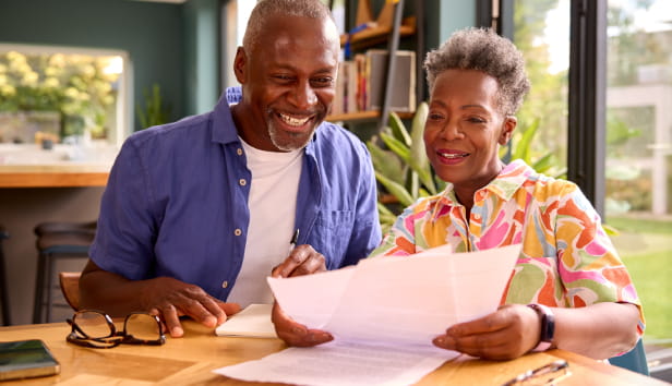 A smiley couple looking at some paperwork