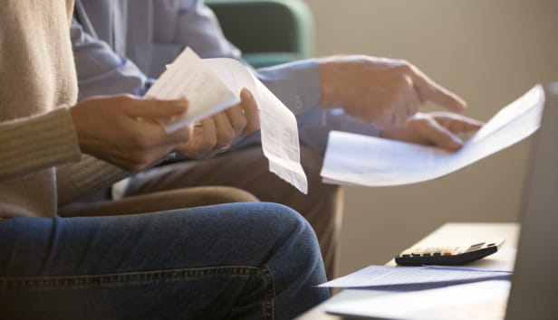 People sat on the sofa holding lots of paperwork