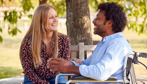 A smiley couple sat in a park