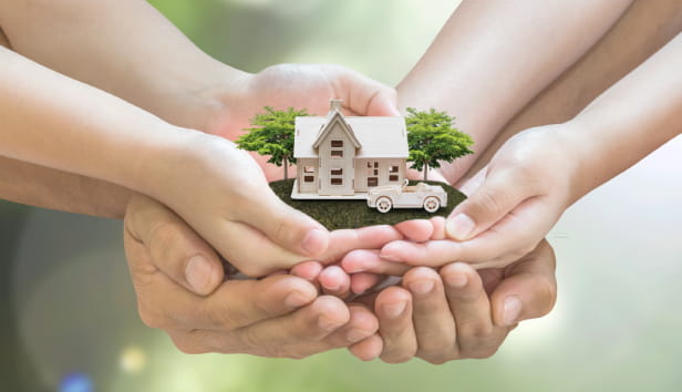 Lots of hands holding a miniature house and car