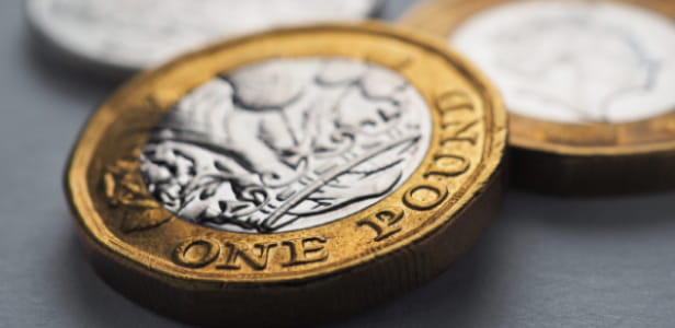 British money lies on gray surface. One coin close-up. Economy and money. Bank of England. UK currency and inflation. Pound horizontal stories. Macro