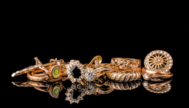 A golden scrap of old gold jewellery on black background