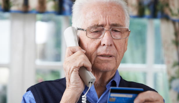 Senior Man Giving Credit Card Details On The Phone