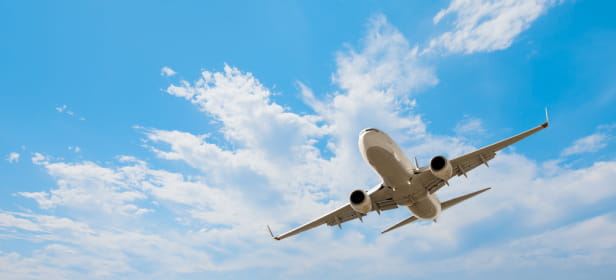 White passenger airplane flying in the sky amazing clouds in the background - Travel by air transport.