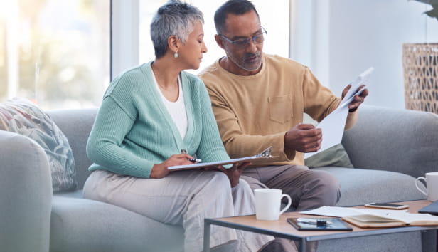 Finance, documents and senior couple on sofa with bills, paperwork and insurance checklist in home, life or asset management, Elderly black people on couch with financial, retirement or mortgage debt
