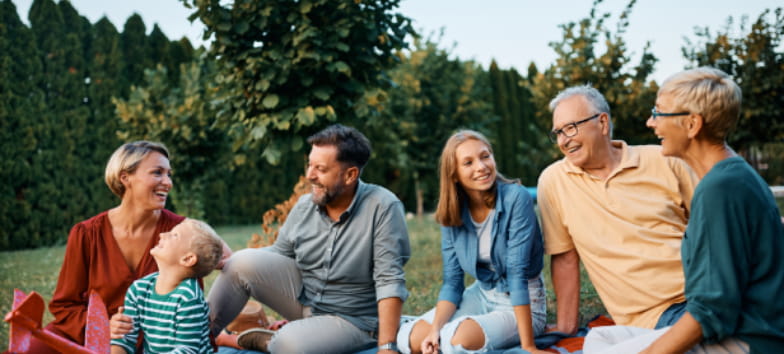 Happy extended family enjoying in conversation while relaxing in their backyard. Copy space.
