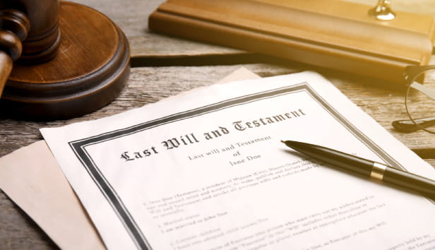 Last Will and Testament, pen and gavel on wooden table, closeup.
