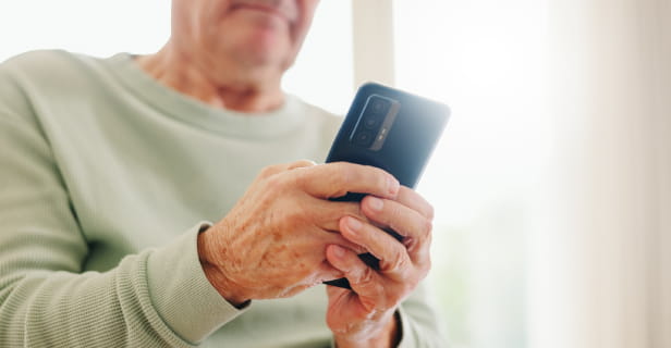 Home, closeup and senior hands with a cellphone, typing and connection with social media, digital app and contact. Old man, pensioner or mature guy with a smartphone, mobile user and search internet.