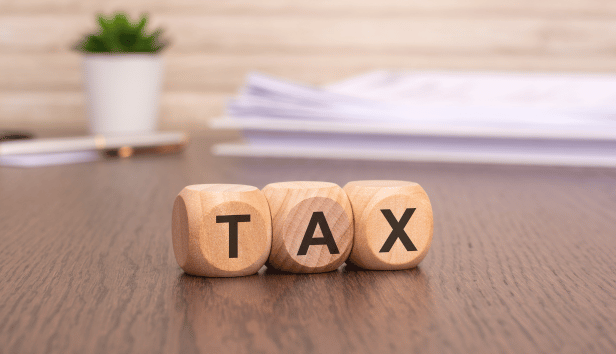 Word TAX written on wooden cubes. Tax concept.