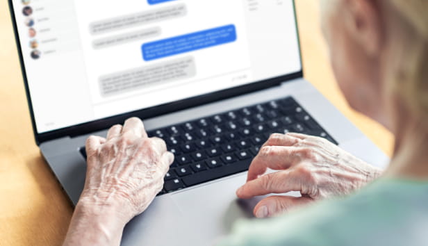 Chat messages in laptop of an old woman. Love fraud scam of catfish. Elder person in online conversation with family. Grandma group messaging. Communication in social media. Customer support chatbot.