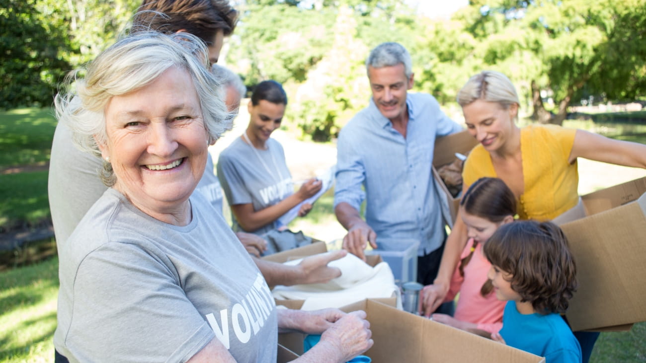Happy volunteer family separating donations stuff on a sunny day