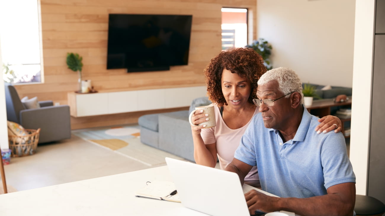 Senior African American Couple Using Laptop To Check Finances At Home.