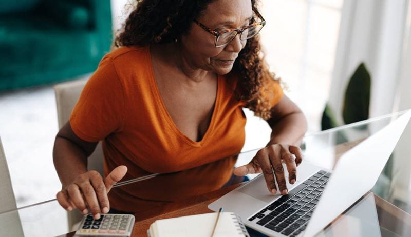 Woman calculating her personal finances, learning to budget and save wisely to ensure a secure and comfortable retirement.
