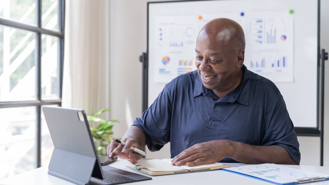 Mature businessman using computer device in office,thinking business solution planning difficult decision pondering strategy.