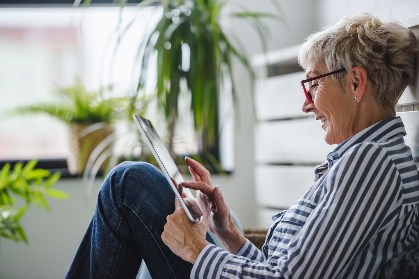 A woman sat comfortably using a tablet on her lap