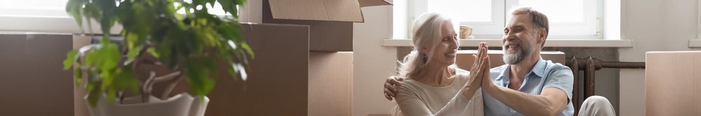 A couple high-fiving surround by boxes in a new house