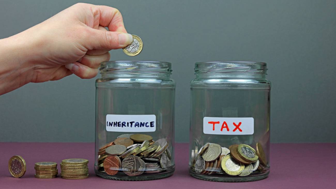 A Hand Putting A Pound Coin In To An Inheritance Fund. The Tax You Pay From Your Inheritance Pot Concept.