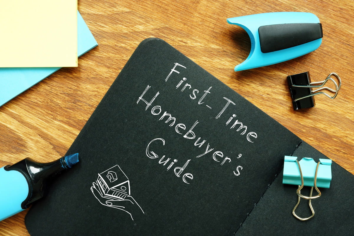 A book  on a desk with first time homebuyer's guide written on the cover