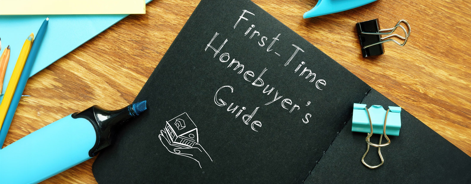A book on a desk with first time homebuyer's guide written on the cover