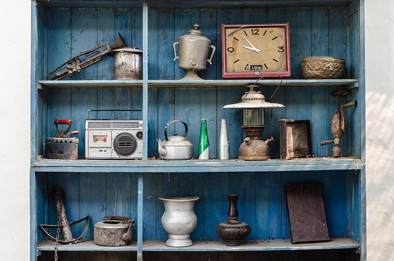 Blue shelves displaying antique items