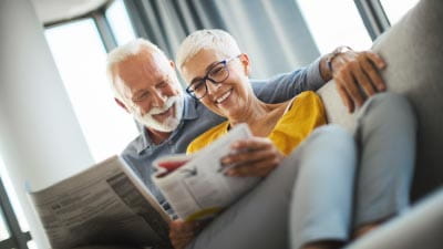 A couple reading the Saga Equity Release guide on the sofa