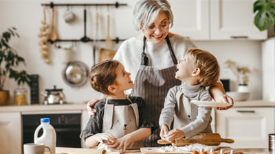 A grandmother with her grandchildren at home in the kitchen