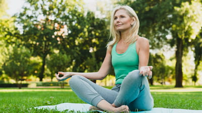 A woman doing yoga outside on a sunny day