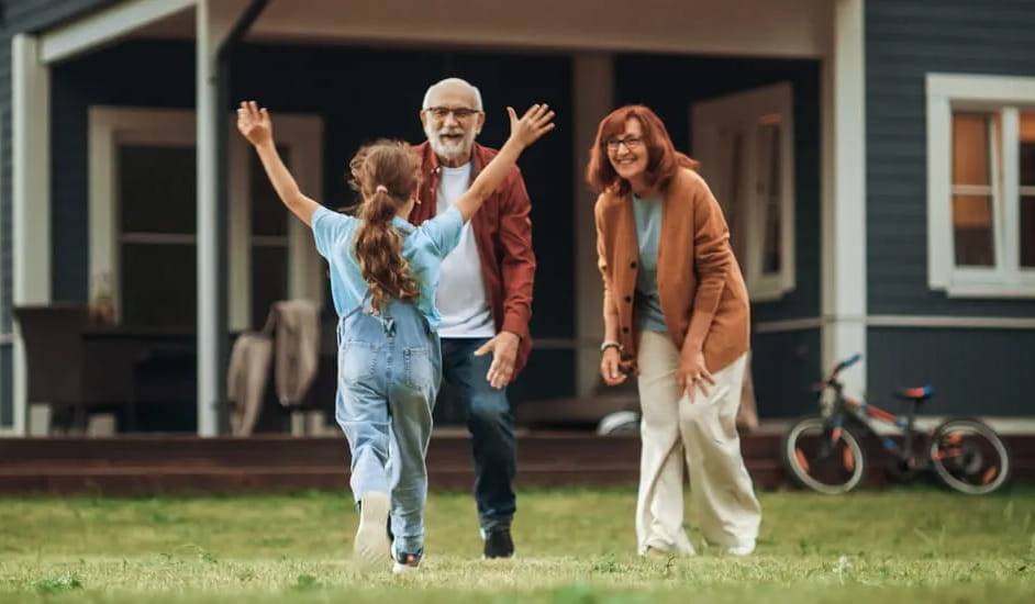 A young girl running towards her grandparents
