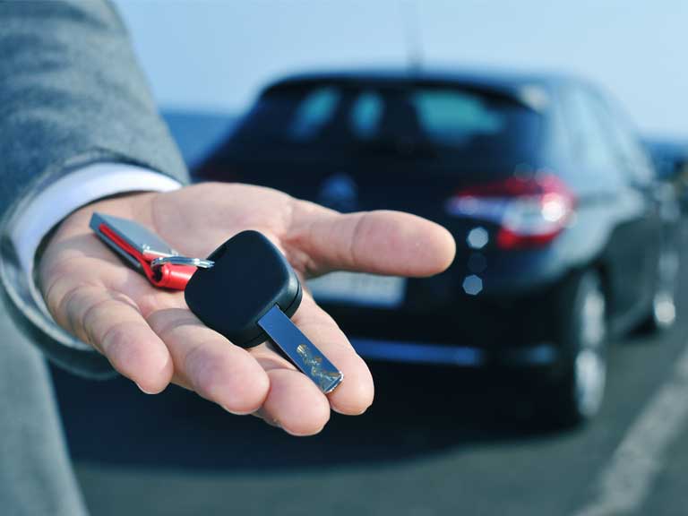 Car rental salesman handing over a hire car key