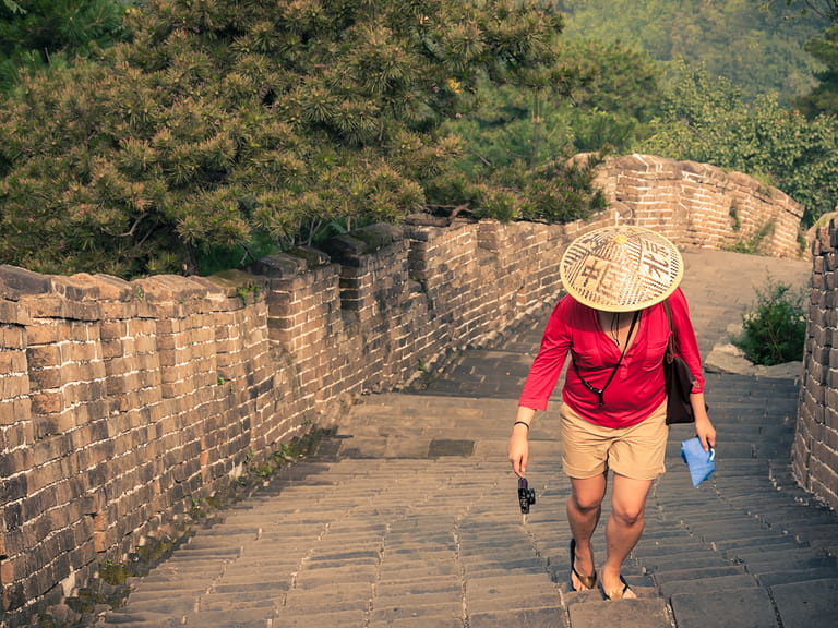 Solo travel lady walking along the Great Wall of China